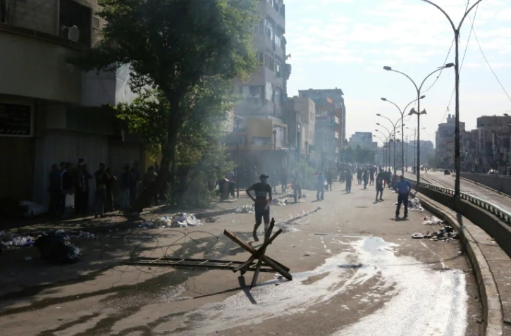 Des forces de sécurité tirent des gaz lacrymogènes sur les manifestants sur la place Tahrir à Bagdad, le 26 octobre 2019
