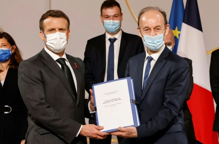 L'historien français Vincent Duclert remet au président français Emmanuel Macron (g) un rapport sur la politique française au Rwanda entre 1990 et 1994 dans la salle des fêtes du palais de l'Elysée à Paris, le 26 mars 2021