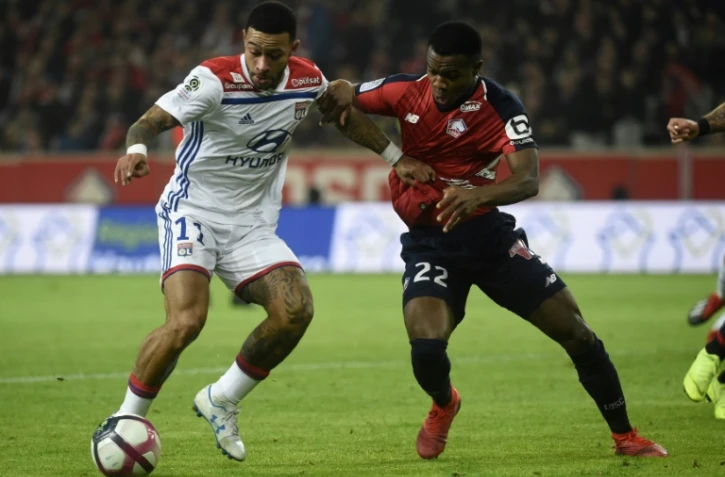 L'attaquant néerlandais de Lyon Memphis Depay (g) à la lutte avec le défenseur ivoirien de Lille Yves Dabila le 1er décembre 2018 à Villeneuve-d'Ascq