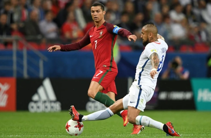 L'attaquant star du Portugal Cristiano Ronaldo (g) à la lutte avec le milieu du Chili Arturo Vidal en demies de la Coupe des Confédérations, le 29 juin 2017 à Kazan