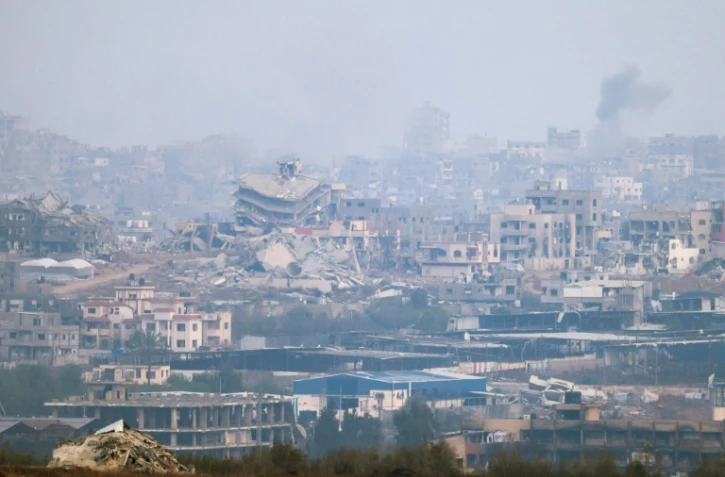 Une photo prise depuis  la frontière israélienne avec la bande de Gaza montre dees destructions et de la fumée s'élevant au dessus du territoire palestinien après des raids israéliens, le 18 mai 2025