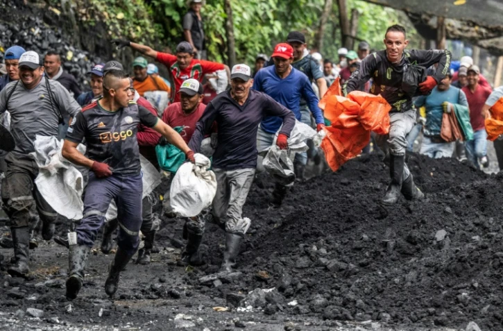 Des chercheurs d'émeraudes à l'ouverture de "La Voladora" à Muzo, département de Boyaca, Colombie, le 19 juin 2024