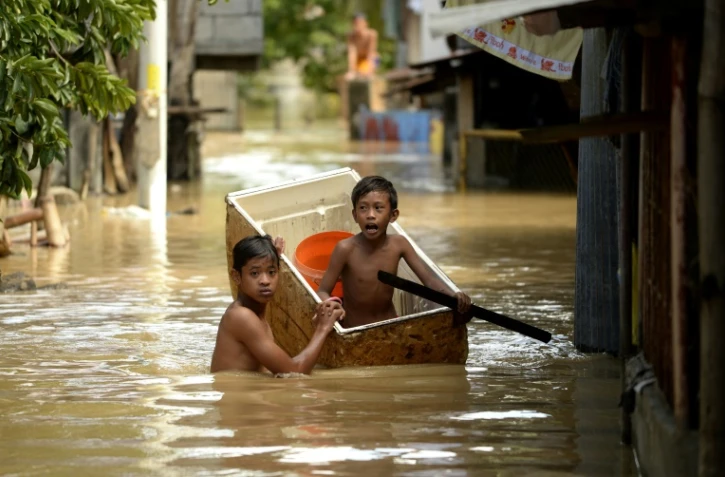 Des enfants dans une rue inondée le 18 décembre 2015 à Candaba aux Philippines