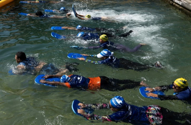 Des mères des quartiers Nord de Marseille participent à un cours de natation dispensé par l'association "Le Grand Bleu" dans une piscine d'eau de mer près du port de l'Estaque, le 11 août 2025