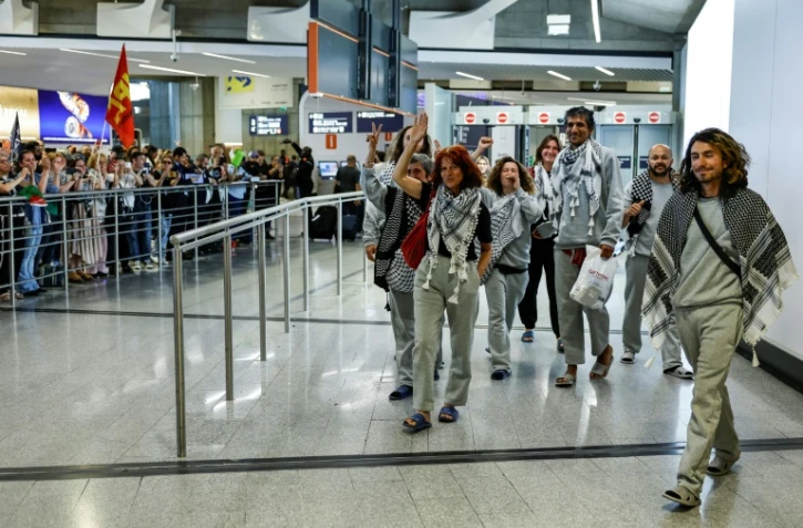 Des militants français, détenus et expulsés par Israël après l'interception de leur flottille à destination de Gaza, accueillis par des sympathisants à leur arrivée à l'aéroport Roissy Charles-de-Gaulle, près de Paris, le 22 mai 2026