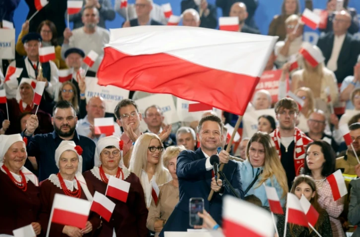 Le maire pro-UE de Varsovie, Rafal Trzaskowski, candidat à la présidentielle polonaise, brandit un drapeau polonais devant ses sympathisants, à Sandomierz, à l'issue du 1er tour, le 18 mai 2025