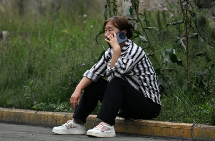 Une proche attend des nouvelles d'un mineur porté disparu après un coup de grisou dévastateur qui a tué au moins 82 ouvriers, le 24 mai 2026 dans le district administratif de Qinyuan, dans la province chinoise septentrionale du Shanxi