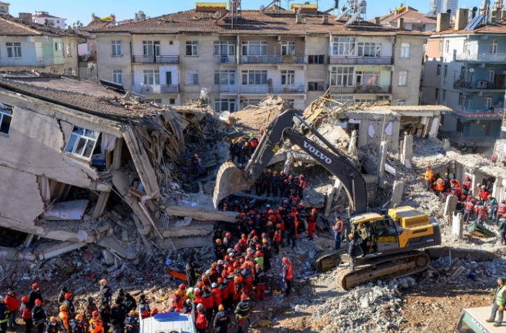 Des équipes de secours retirent des corps des décombres d'un immeuble effondré lors d'un puissant séisme, le 26 janvier 2020 à Elazig, en Turquie