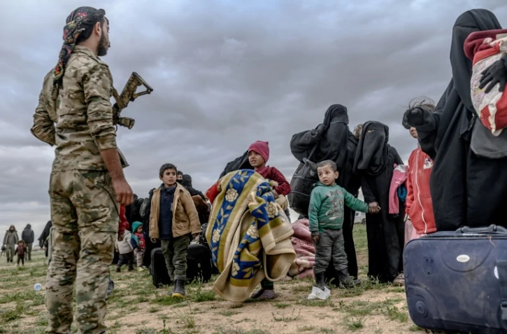 Un combattant des Forces démocratiques syriennes encadre des femmes et des enfants évacuées de Baghouz, le 27 février 2019 
