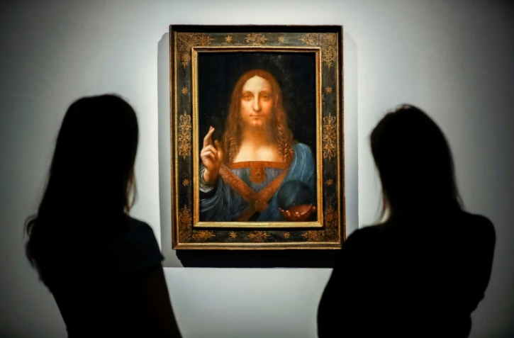 Des employés de Christie's regardent le 22 octobre 2017 à Londres le tableau du peintre italien Léonard de Vinci adjugé 450,3 millions de dollars le 15 novembre 2017 à New York