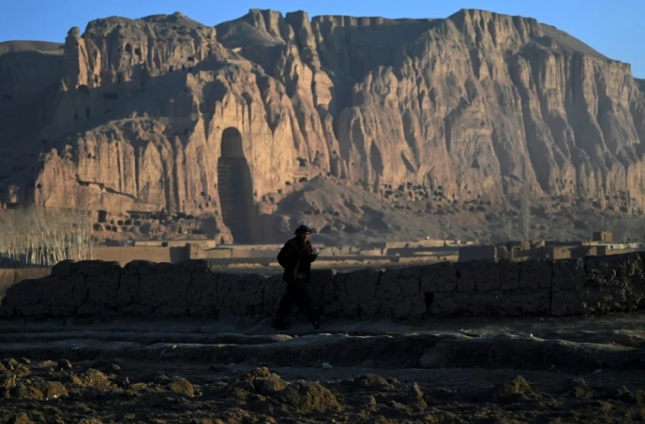 Un homme passe le 5 mars 2021 devant le site de Bamiyan en Afghanistan où deux Bouddhas géants sculptés dans la falaise ont été dynamités par les talibans en mars 2001