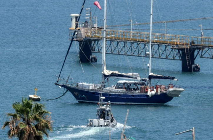Un bateau de patrouille de la police israélienne se dirige le bateau Madleen amarré au port d'Ashdod après avoir été intercepté la veille par les forces israéliennes, le 10 juin 2025