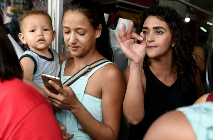 Une partisane (droite) du candidat d'extrême droite Jair Bolsonaro discute avec un partisan (hors cadre) du candidat de gauche Fernando Haddad, lors d'un meeting de campagne du Parti des travailleurs, à Belo Horizonte (Etat du Minas Gerais) le 5 octobre 2018