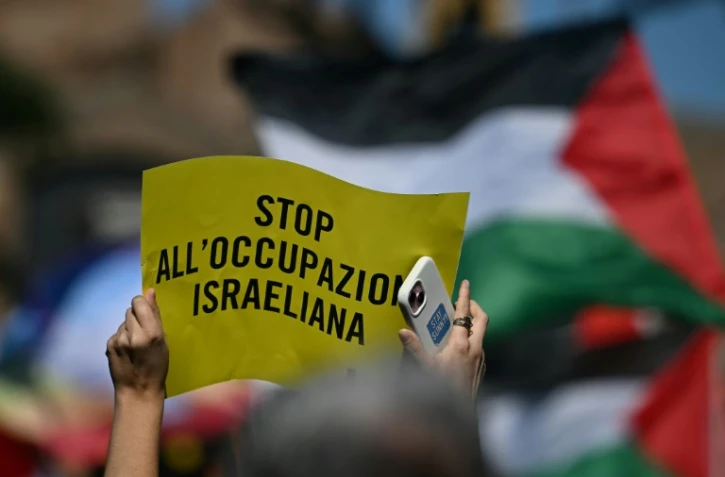 Une personne tient une pancarte "Stop à l'occupation israélienne" lors d'une manifestation en solidarité avec les Palestiniens et pour protester contre l'interception de la flottille Global Sumud par l'armée israélienne, à Rome, le 3 octobre 2025