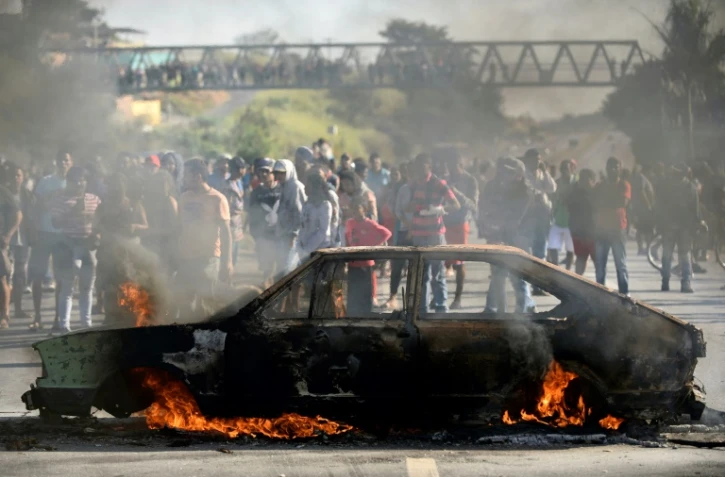 Des manifestants brûlent une voiture sur une route pour dénoncer la hausse des prix du diesel à Ribeirao das Neves au Brésil, le 25 mai 2018