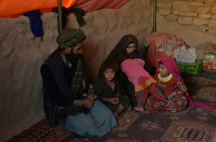 Les fillettes Farishteh, 6 ans, (d) et Shokriya (2e) un an et demi, avec leurs parents et leur frère, sous une tente du camp de déplacés de Qala-i-Naw, le 14 octobre 2021 en Afghanistan