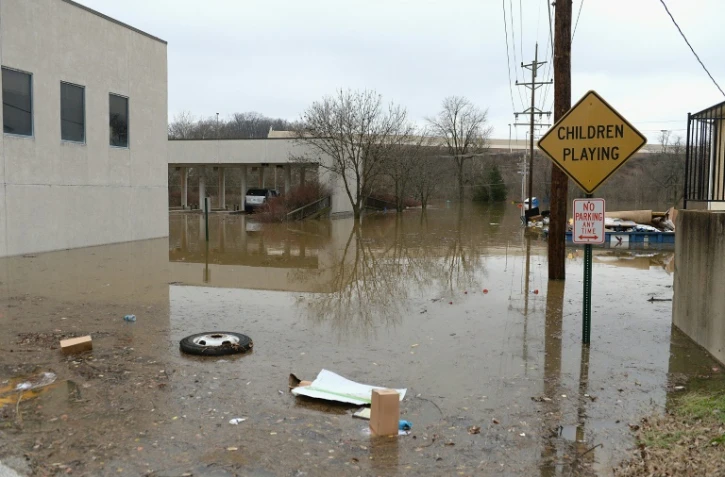 Des détritus et des gravats charriés dans une rue après la crue d'un cours d'eau, le 30 décembre 2015 à Fenton (Missouri)