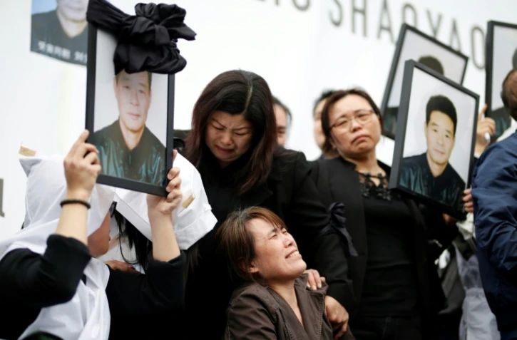 La veuve de Liu Shaoyao (assise au centre) lors d'un rassemblement, le 2 avril 2017 à Paris, suite à la mort de ce père de famille chinois tué la semaine dernière par un policier