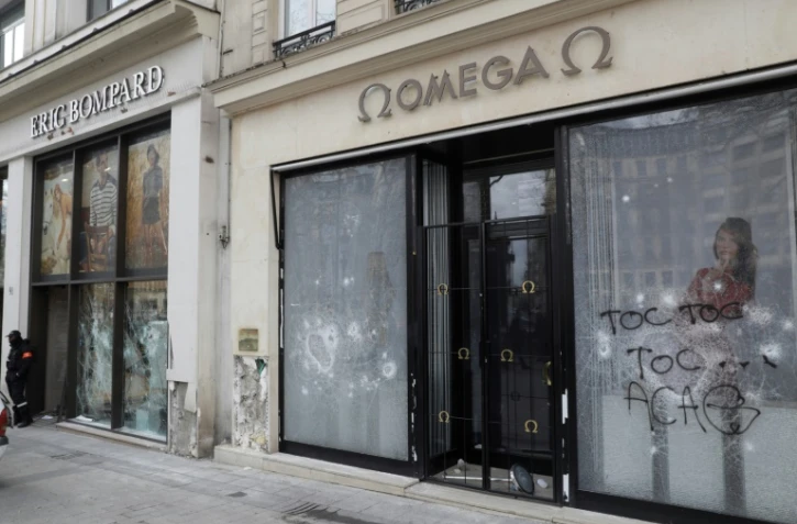 Les vitrines brisées et taguées de boutiques sur les Champs-Elysées, au lendemain de la manifestation des "gilets jaunes", le 17 mars 2019 à Paris


