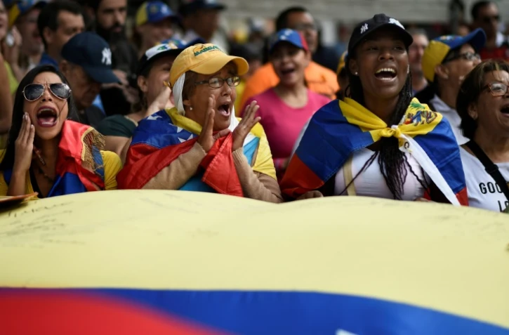 Des partisans du chef de l'opposition vénézuélienne Juan Guaido se rassemblent le 12 février 2019 dans l'est de Caracas pour faire pression sur l'armée afin qu'elle laisse entrer l'aide humanitaire américaine