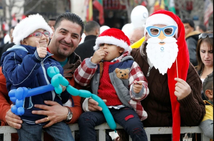 Des Palestiniens assistent place de la Mangeoire à la parade des scouts, le 24 décembre 2016 à Bethléem, dans les Territoires palestiniens