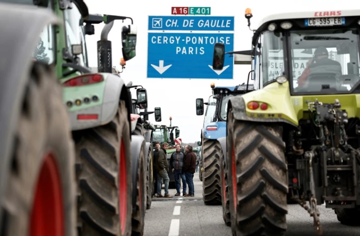 Des agriculteurs français ont arrêté leurs tracteurs sur l'autoroute A16 près de l'Isle-Adam, le 30 janvier 2024, dans l'un des barrages routiers installés sur les principales autoroutes vers Paris pour une deuxième journée d'action