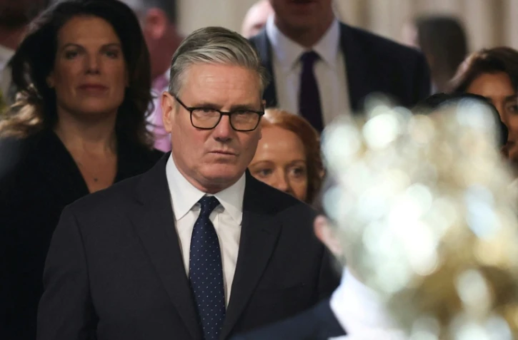 Le Premier ministre britannique Keir Starmer (c) retourne à la Chambre des communes après avoir écouté le discours du roi lors de l'ouverture solennelle du Parlement au palais de Westminster, le 13 mai 2026 à Londres