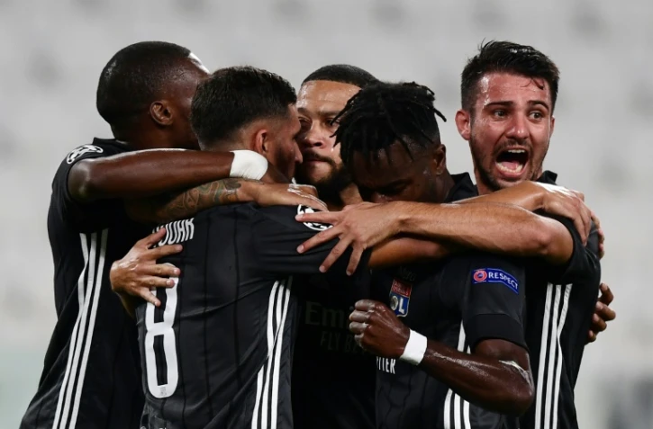 Des joueurs de l'Olympique lyonnais félicitent Memphis Depay après son pénalty inscrit contre la Juventus Turin en 8e de finale retour de la Ligue des champions le 7 août 2020 à Turin 