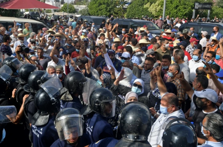Des forces de sécurité repoussent des manifestants devant le Parlement, à Tunis, le 26 juillet 2021