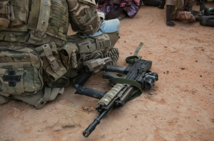 Un soldat de l'ONU au Mali a mis son arme au sol pour parler à des villageois près de Menaka le 28 octobre 2021