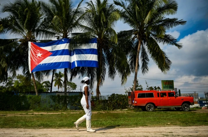 Une femme passe devant un drapeau cubain Ã  La Havane, le 1er fÃ©vrier 2022