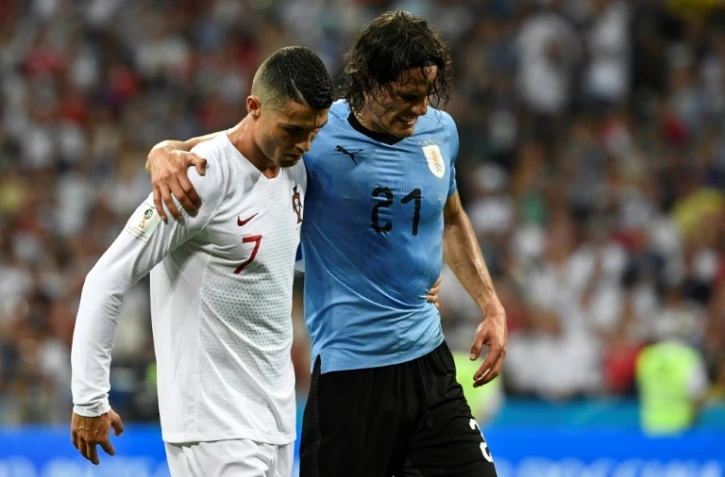 L'attaquant uruguayen Edinson Cavani blessé quitte le terrain soutenu par le Portugais Cristiano Ronaldo lors des 8e de finale du Mondial le 30 juin 2018