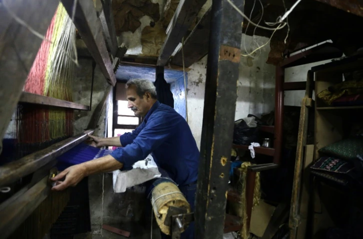 Ahmed Chakaki travaille son métier à tisser dans son atelier à Damas, le 1er décembre 2015