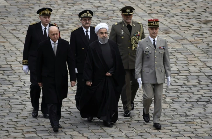 Le président iranien Hassan Rohani (c), le ministre français des Affaires étrangères Laurent Fabius, lors d'une cérémonie aux Invalides, le 28 janvier 2016 à Paris