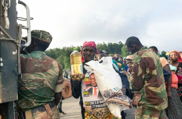 Des villageois reçoivent de la nourriture le 18 mars 2019, à Chimanimani, au Zimbabwe, après le passage du cyclone Idai.