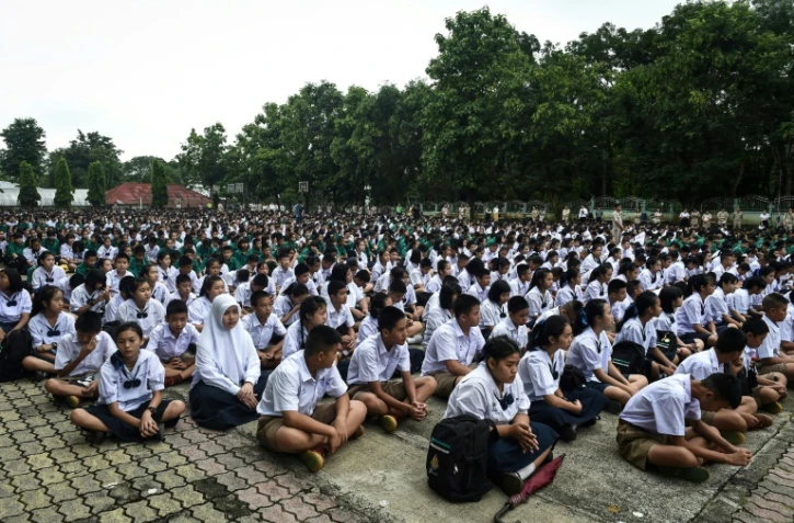 Des camarades d'école des douze enfants disparus avec leur entraîneur dans une grotte en Thaïlande prient pour qu'ils soient retrouvés, le 2 juillet 2018 à Mae Sai 