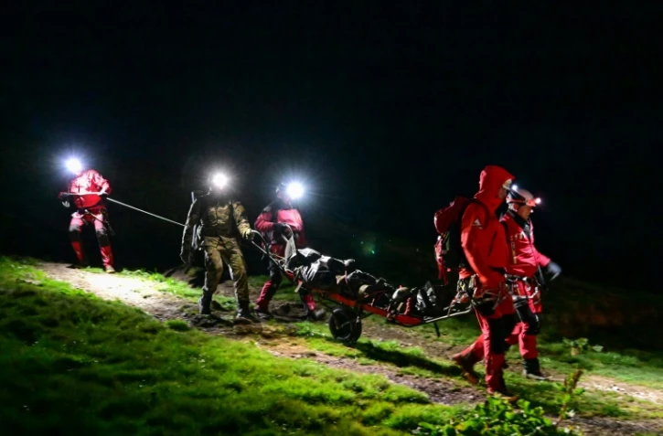Des militaires de secours en montagne transportent les corps de deux Ukrainiens retrouvés morts sur un terrain accidenté proche de la frontière entre la Roumanie et l’Ukraine dans les montagnes de Maramures, le 15 mai 2024