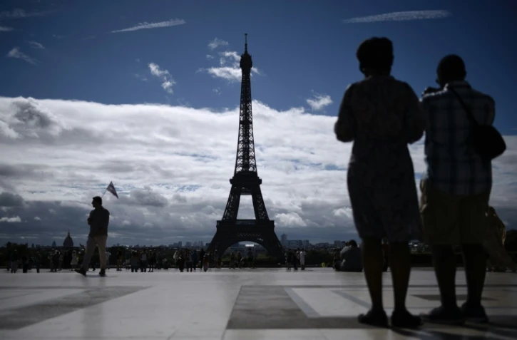 Des touristes contemplent la Tour Eiffel de la Place du Trocadéro à Paris, le 3 août 2017
La fréquentation touristique en France a bondi au deuxième trimestre