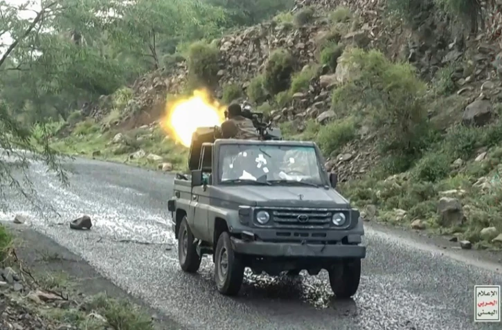Image tirée d'une vidéo publiée par le centre médiatique d'Ansarullah le 7 octobre 2026 montrant un combattant houthi tirant avec une mitrailleuse montée sur un camion lors d'une progression contre les troupes du gouvernement yéménite dans la région de Taëz, selon les médias houthis