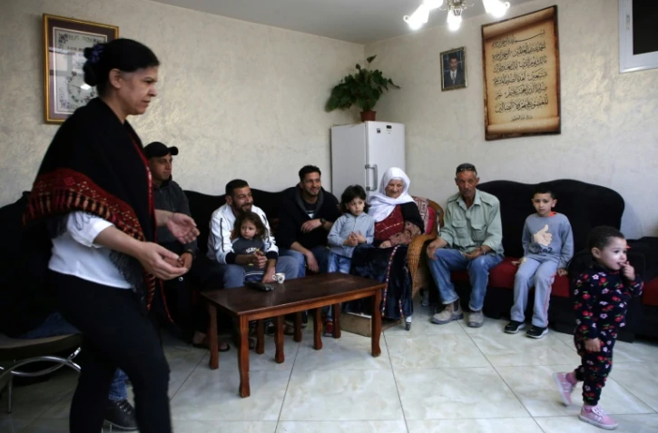 Khadija Sharkawi (C) est assise avec les membres de sa famille dans sa maison située dans le camps de réfugiés d'Al-Amari en Cisjordanie occupée, le 08 mai 2018
