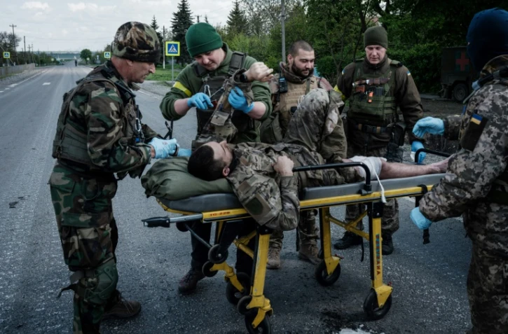 Des soldats ukrainiens évacuent un blessé près de Lyssytchansk, dans l'est de l'Ukraine, le 10 mai 2022
