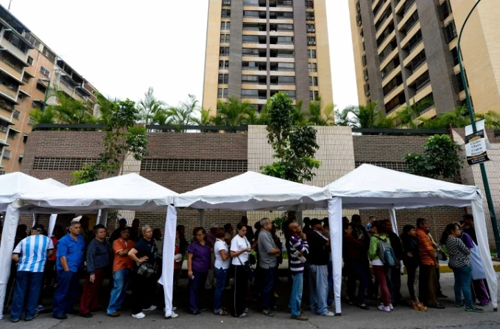 Des Venezuéliens font la queue pour authentifier leur signature en faveur d'un référendum pour déposer le président Nicolas Maduro, à Caracas, le 20 juin 2016
