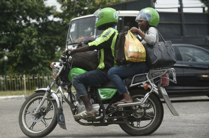 Une femme passagère d'un taxi-moto ORide, le 30 août 2019 à Lagos, au Nigeria