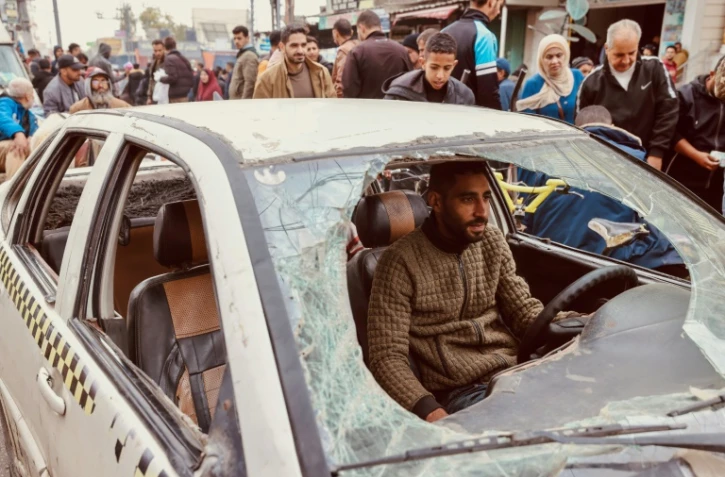 Un Palestinien conduit sa voiture endommagée lors d'un bombardement israélien, le 23 décembre 2023 à Rafah, dans la bande de Gaza