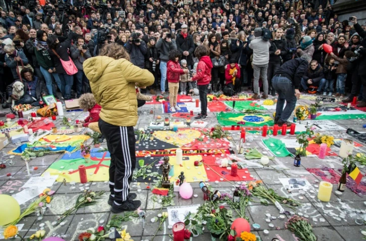 Une minute de silence est observée sur la Place de la Bourse à Bruxelles le 23 mars 2016 en hommage aux victimes des attentats qui ont frappé la veille la capitale belge