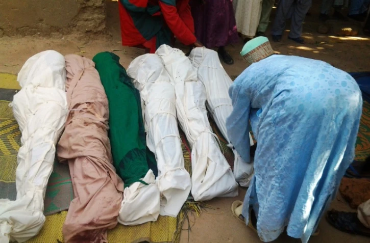 Un habitant enveloppe des cadavres avec des linceuils après une attaque de bandits dans la province de Zamfara au Nigéria, le 18 juin 2013