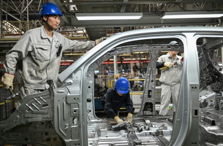 Des employés travaillent sur une ligne de production de véhicules électriques à l'usine Leapmotor de Jinhua, en Chine, le 18 septembre 2024