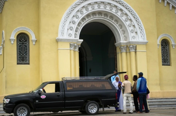 Un prêtre reçoit les proches d'une personne décédée, à La Havane le 27 janvier 2016