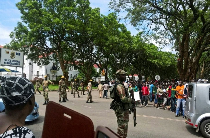Des soldats zimbabwéens patrouillent devant les locaux de la police lors d'une manifestation à Harare, le 18 novembre 2017