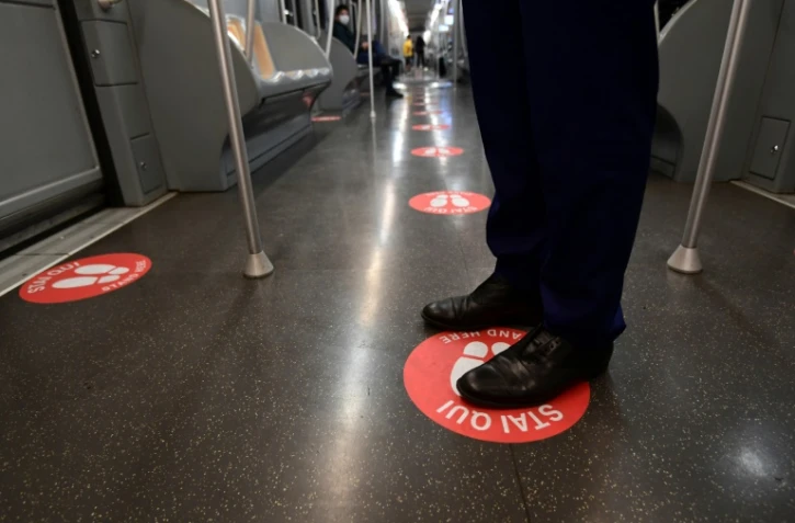 Une rame du métro de Milan avec un autocollant au sol portant l'inscription "Mettez-vous ici", le 28 avril 2020
